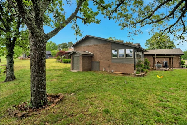 back of house featuring a yard and brick siding