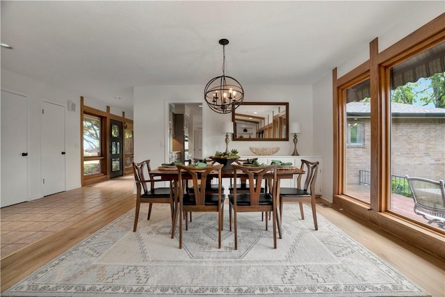 dining room with a chandelier, a healthy amount of sunlight, and light wood-style floors