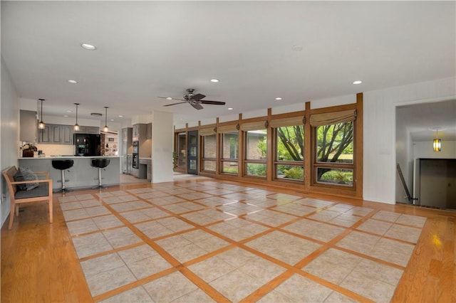 unfurnished living room with light wood-style flooring, ceiling fan, and recessed lighting