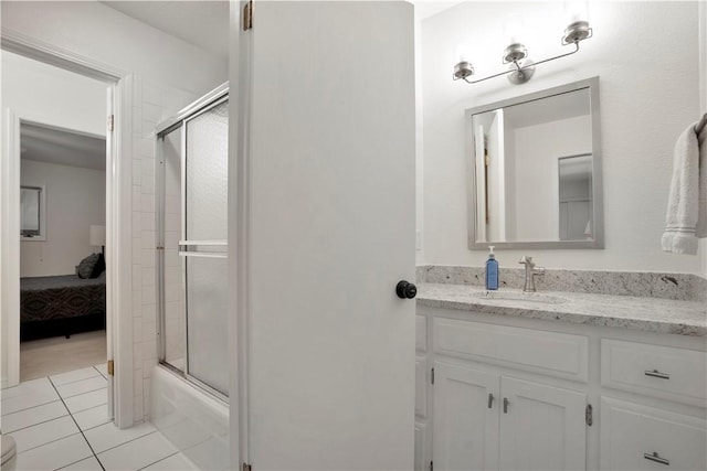 ensuite bathroom with tile patterned floors, an enclosed shower, ensuite bathroom, and vanity