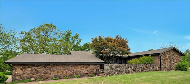 view of property exterior with stone siding and a lawn