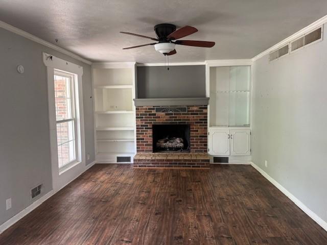 unfurnished living room with visible vents, plenty of natural light, and dark wood finished floors