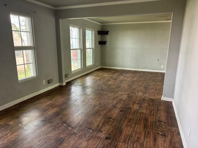 spare room with dark wood-style flooring, baseboards, and ornamental molding