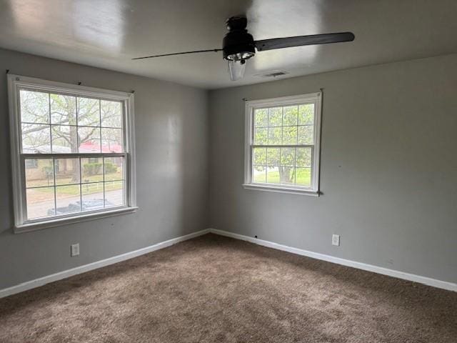 empty room featuring baseboards, carpet flooring, ceiling fan, and visible vents