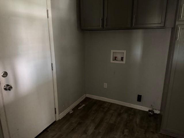 washroom with cabinet space, washer hookup, dark wood finished floors, and baseboards