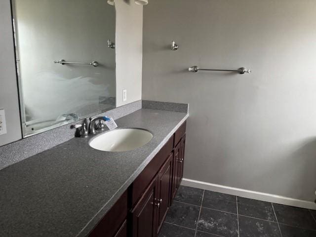 bathroom with vanity, baseboards, and tile patterned flooring