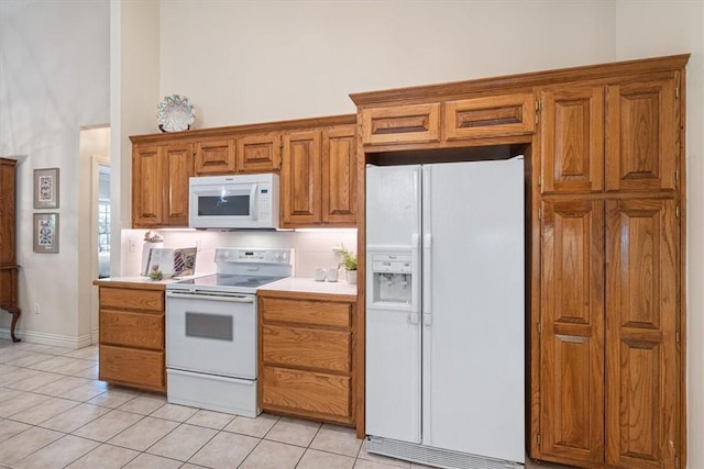 2 Breton Ln, Bella Vista, AR 72715 - kitchen with white appliances, light tile patterned floors, light countertops, brown cabinetry, and a high ceiling