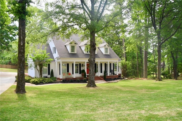 cape cod house with a porch, concrete driveway, roof with shingles, and a front lawn