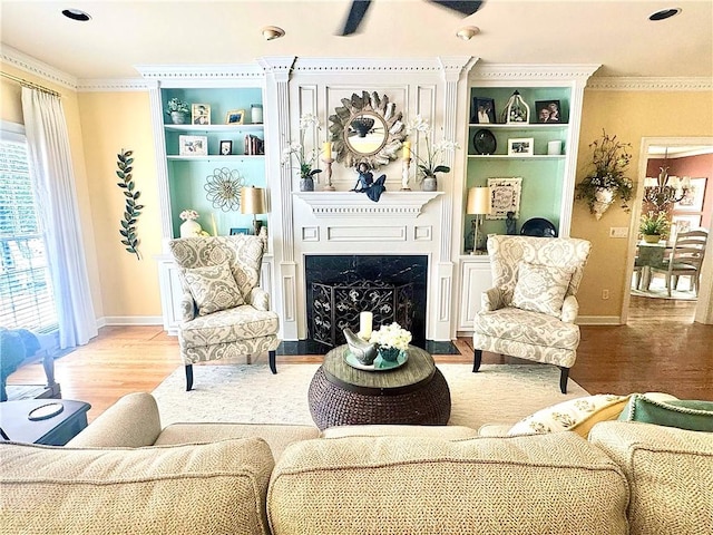 interior space with built in features, baseboards, a fireplace, and wood finished floors