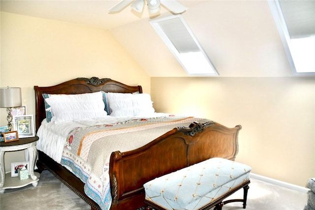 carpeted bedroom featuring ceiling fan, baseboards, and vaulted ceiling with skylight