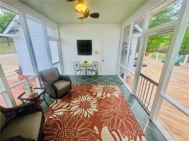 sunroom featuring a ceiling fan and a wealth of natural light