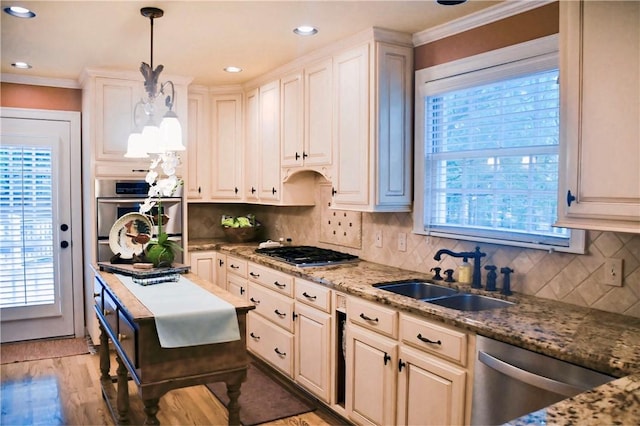 kitchen featuring crown molding, stainless steel appliances, decorative backsplash, and a sink
