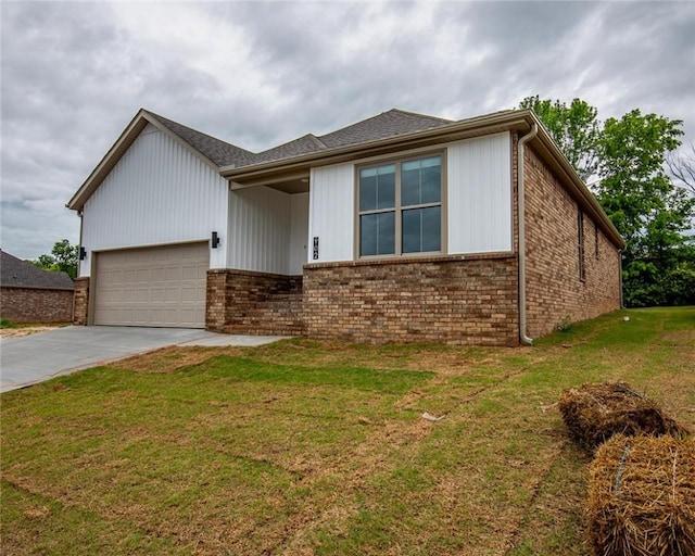 view of front of home featuring concrete driveway, brick siding, an attached garage, and a front yard