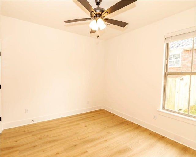 spare room featuring baseboards and light wood-type flooring