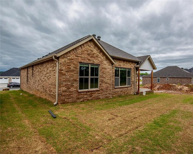 view of property exterior with a yard and brick siding