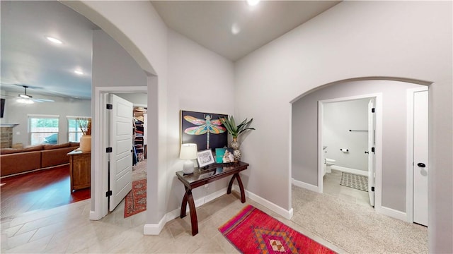 corridor featuring recessed lighting, arched walkways, and baseboards