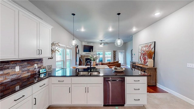 kitchen with a sink, dishwasher, a peninsula, open floor plan, and backsplash