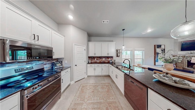 kitchen with white cabinets, appliances with stainless steel finishes, a sink, tasteful backsplash, and visible vents