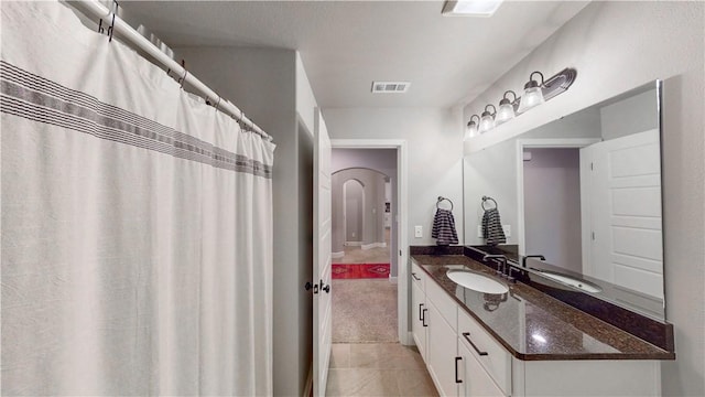 bathroom featuring tile patterned floors, visible vents, baseboards, and vanity