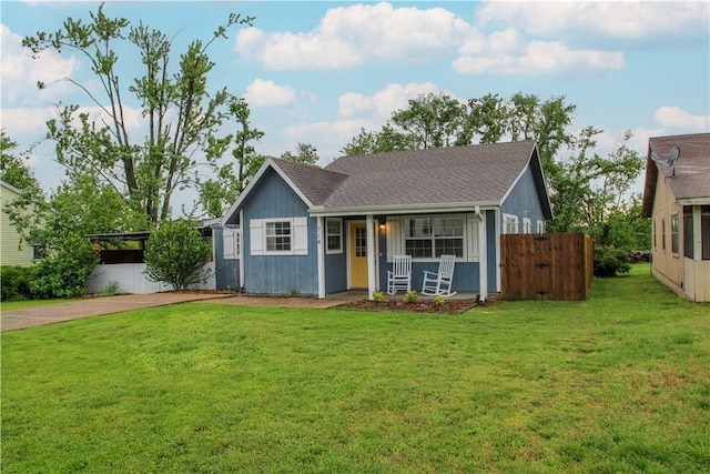 view of front facade with fence, covered porch, and a front yard