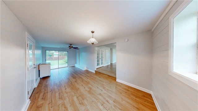 spare room with baseboards, ceiling fan, and light wood-style floors