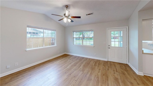 interior space featuring visible vents, a ceiling fan, lofted ceiling, and light wood-type flooring