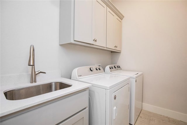 laundry room featuring a sink, baseboards, cabinet space, and washing machine and clothes dryer