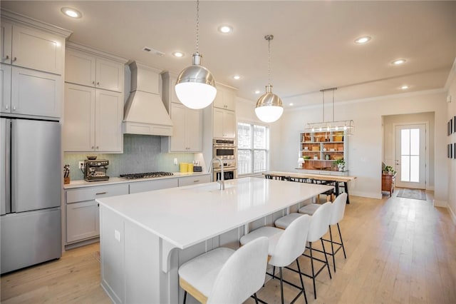 kitchen with appliances with stainless steel finishes, light countertops, recessed lighting, decorative backsplash, and custom range hood