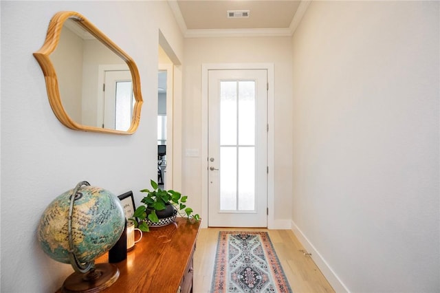 doorway to outside featuring visible vents, light wood-style flooring, crown molding, and baseboards