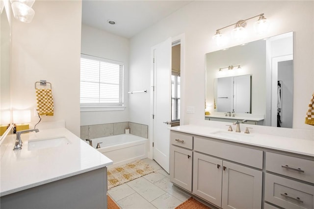 bathroom with a sink, a bath, and two vanities