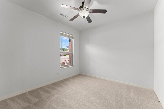 unfurnished room with visible vents, a ceiling fan, baseboards, and light colored carpet