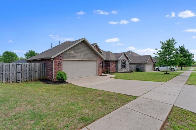 single story home featuring fence, a front yard, brick siding, concrete driveway, and an attached garage