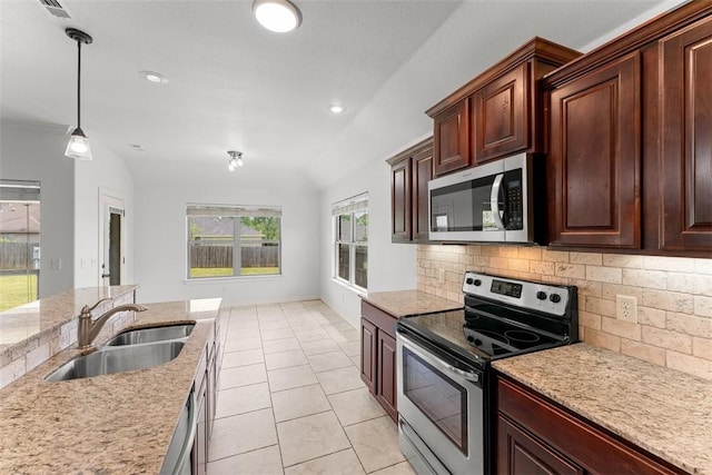 kitchen featuring pendant lighting, a sink, backsplash, light tile patterned floors, and stainless steel appliances