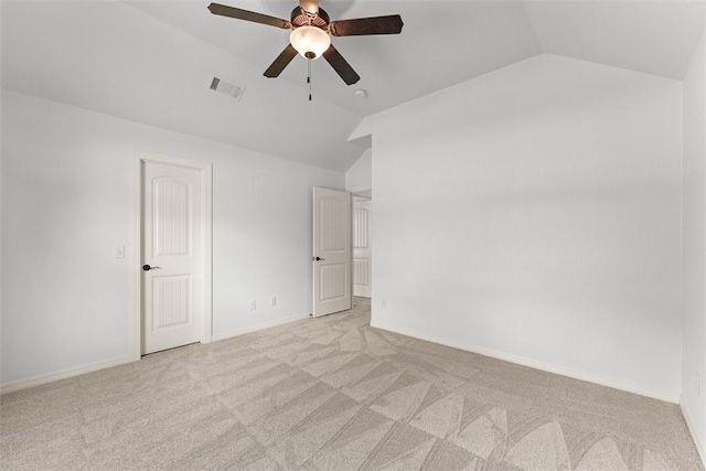 unfurnished bedroom with baseboards, visible vents, light colored carpet, and lofted ceiling