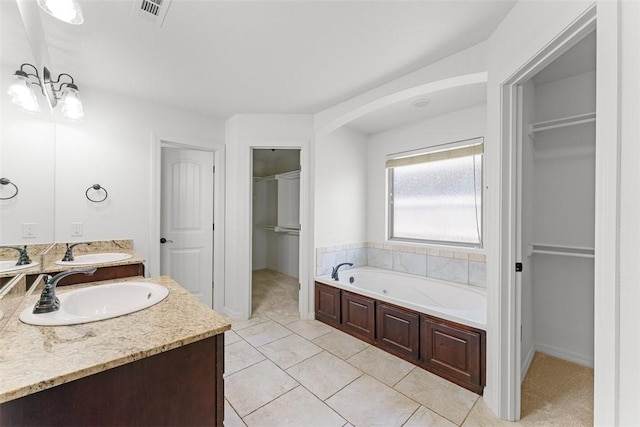 full bathroom featuring a sink, a bath, double vanity, and visible vents