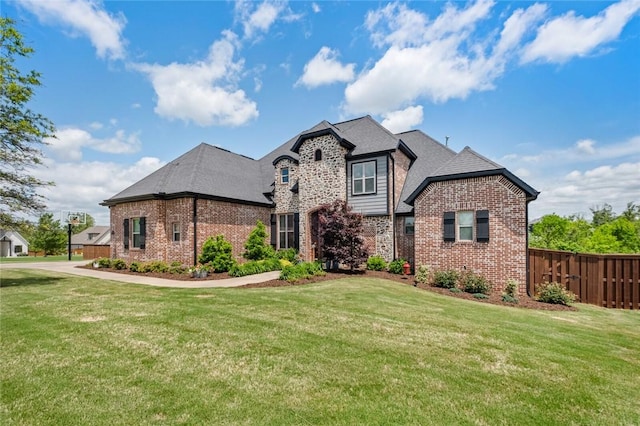 view of front of property with fence, a front yard, and brick siding