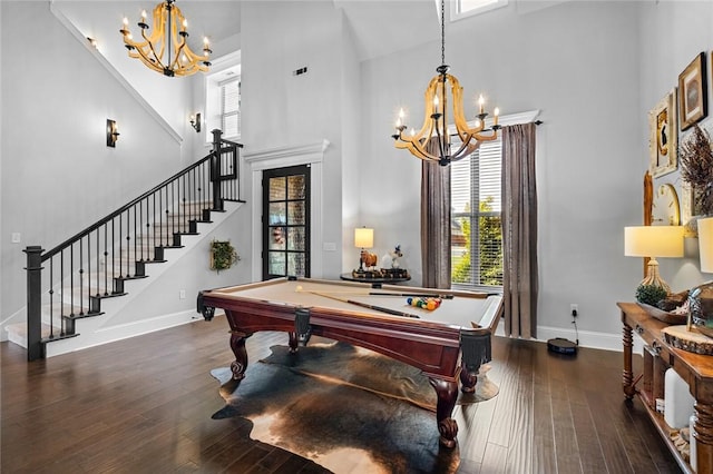 rec room with an inviting chandelier, a wealth of natural light, and a towering ceiling