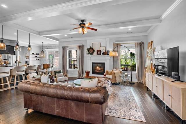 living area with dark wood-type flooring, ornamental molding, coffered ceiling, and a glass covered fireplace