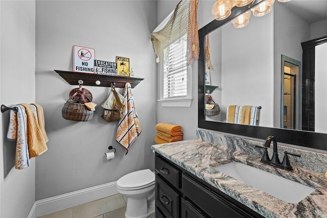 bathroom with tile patterned floors, baseboards, vanity, and toilet
