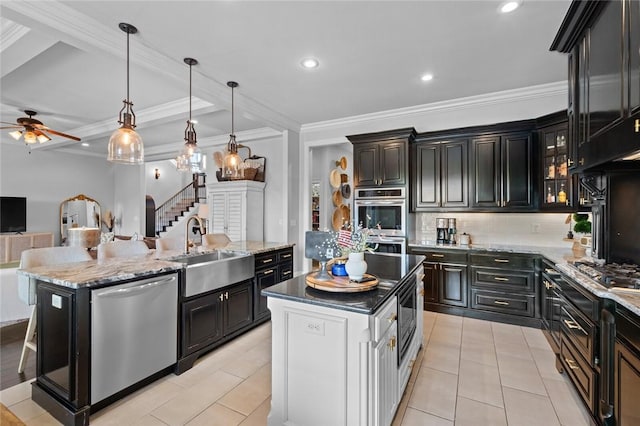 kitchen with a sink, an island with sink, backsplash, and stainless steel appliances