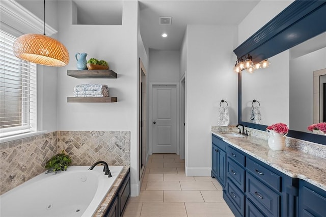 bathroom with tile patterned flooring, a whirlpool tub, visible vents, and vanity