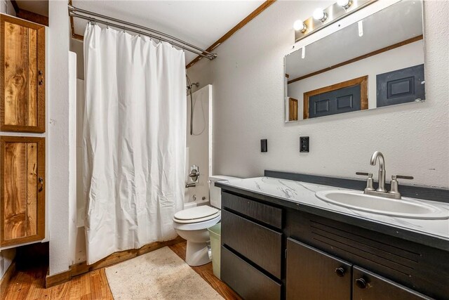 full bath featuring vanity, shower / tub combo with curtain, wood finished floors, and toilet