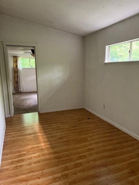unfurnished room featuring baseboards and light wood finished floors