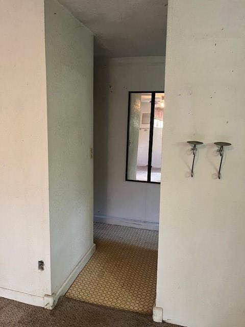 hall with carpet floors and baseboards