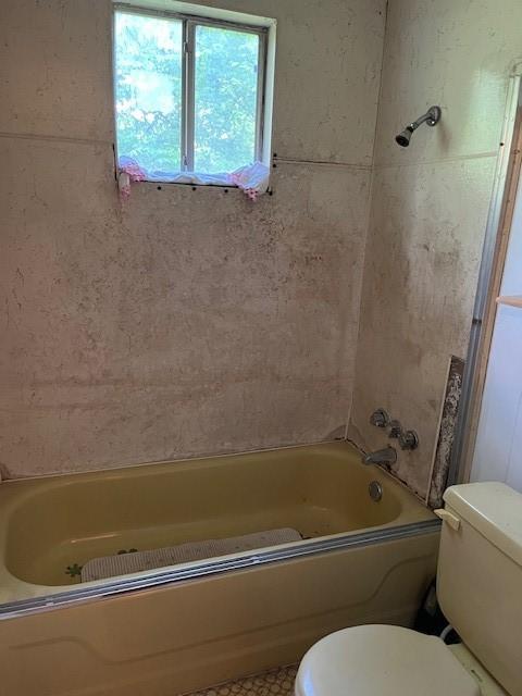 bathroom with shower / bathtub combination and toilet