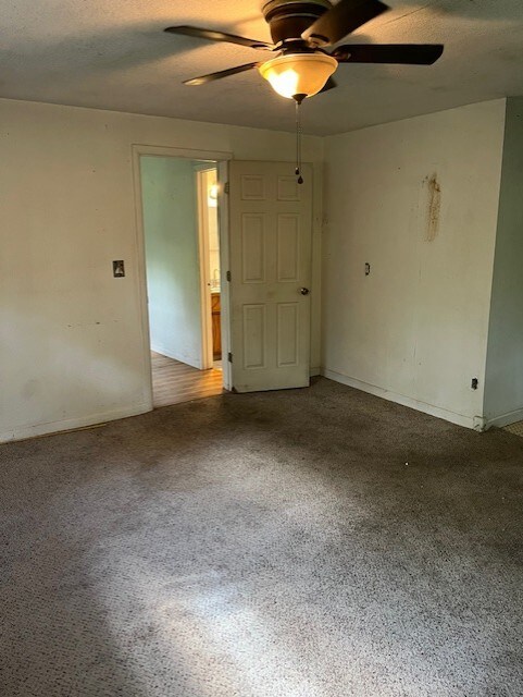 unfurnished room with baseboards and a ceiling fan