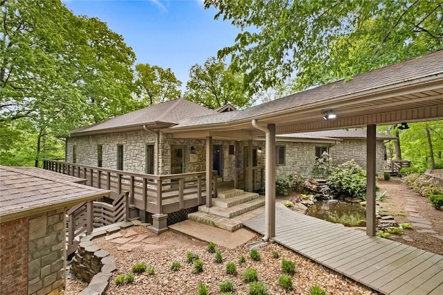 10 Spring Valley Dr, Bentonville, AR 72712 - rear view of property featuring roof with shingles, stone siding, and a deck