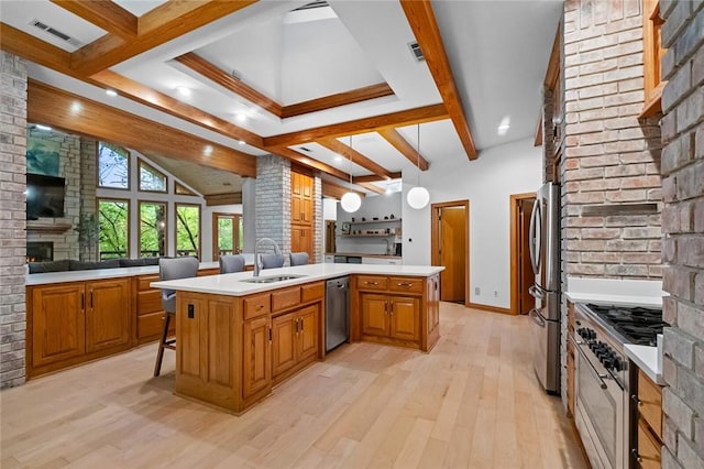 10 Spring Valley Dr, Bentonville, AR 72712 - kitchen featuring brown cabinets, a sink, stainless steel appliances, open floor plan, and light wood-type flooring