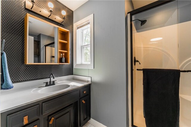 full bath featuring a shower stall, vanity, backsplash, and baseboards