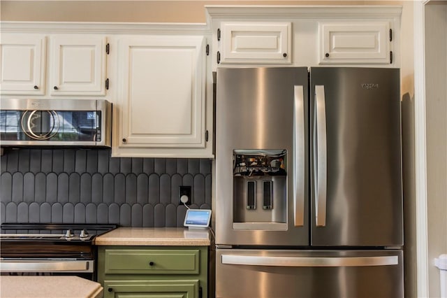 kitchen with appliances with stainless steel finishes, green cabinets, backsplash, light countertops, and white cabinetry
